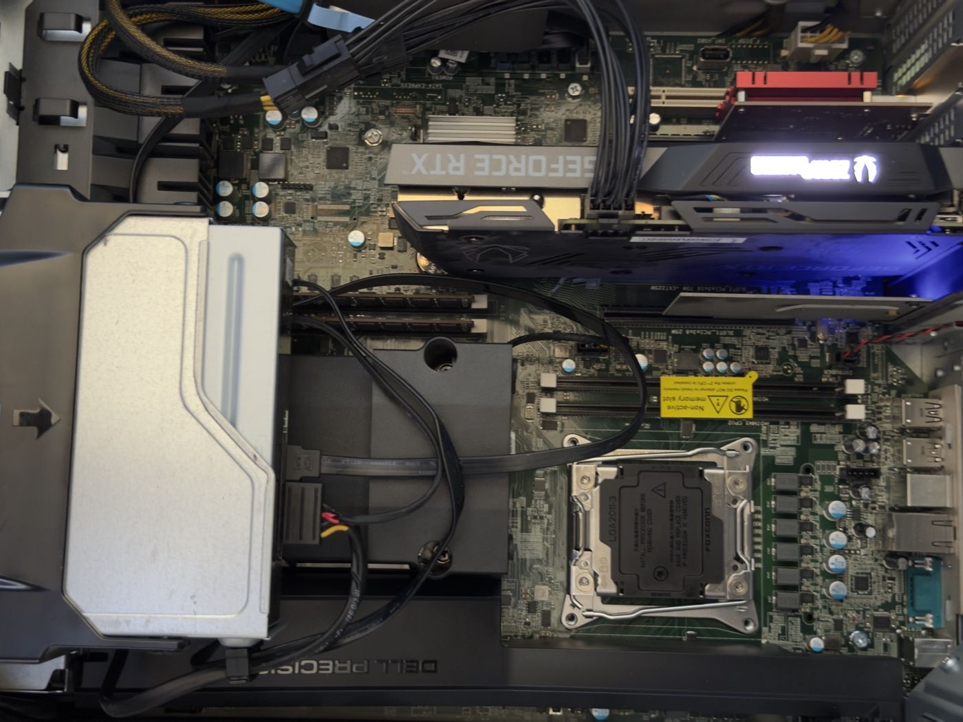 Close-up of an empty LGA2011-3 CPU socket with its protective cover on, beside a yellow sticker reading Non-active memory slot.